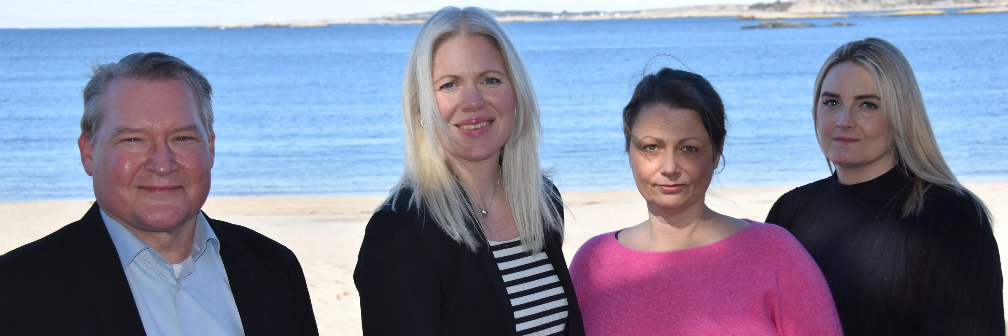 Employees at Viscio Ekonomi on a beach in front of the ocean